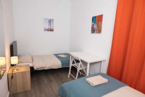 a room with two beds and a desk and a table at Apartment Carrer de Joan in Barcelona