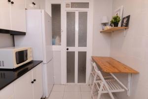 eine kleine Küche mit einem Tisch und einer Mikrowelle in der Unterkunft Apartment Carrer de Joan in Barcelona