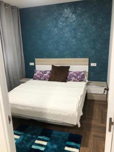 1 dormitorio con 1 cama con pared azul en Apartamento La Plana, en Castellón de la Plana