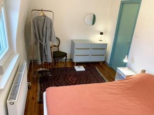 um quarto com uma cama, uma cómoda e um roupão em CosyAttic em Saint-Louis