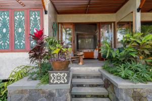 une terrasse couverte d'une maison avec des plantes et des escaliers dans l'établissement Inara Alas Harum, à Gianyar