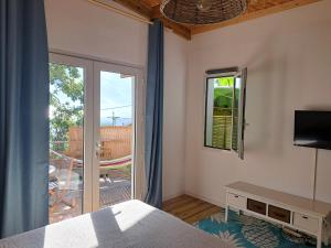 a bedroom with a bed and a sliding glass door at La belle Cabane in Saint-Leu
