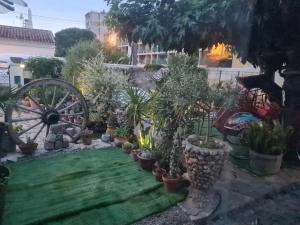 a garden with a wagon wheel and potted plants at rez de maisons in Avignon