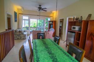 a dining room and living room with a green table and chairs at The Dudek's Nest B&B in Ngermid