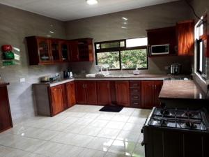 eine große Küche mit Holzschränken und einem Fenster in der Unterkunft La Source Self Catering in La Digue