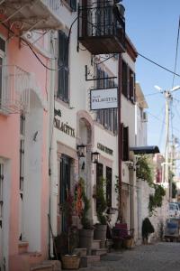 a group of buildings with potted plants on a street at Ayvalık Palacitta Guesthouse in Ayvalık