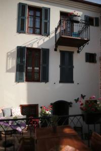 a white building with windows and a balcony with flowers at Ayvalık Palacitta Guesthouse in Ayvalık