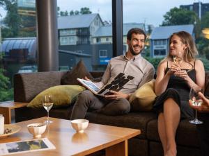 un hombre y una mujer sentados en un sofá con copas de vino en AYA Villa en Niseko