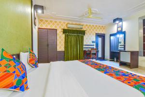 1 dormitorio con 1 cama grande y escritorio en FabHotel Prime Surpin Palace, en Kota