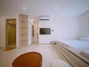 ein Schlafzimmer mit einem Bett und einem TV an der Wand in der Unterkunft BOBO HOMESTAY in Ða Tốn