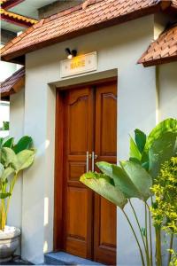 una puerta a una casa con un cartel encima en Villa MARIE - KUTA - 6 Bedroom 4 Bathroom Villa - Great Location !, en Kuta