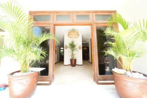 Villa MARIE - KUTA - 6 Bedroom 4 Bathroom Villa - Great Location ! في كوتا: اثنين من نباتات الفخار الكبيرة أمام الباب
