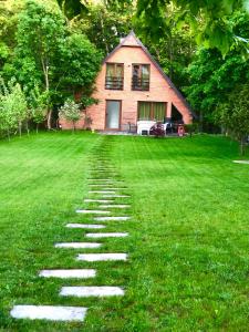 a stone path in the grass in front of a house at Cozy 3 bedroom mountain villa with scenic views in Novoberdo