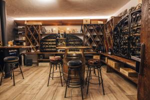 a bar with stools in a room with wine racks at CHRIStania in Fiesch