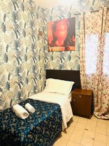 Dormitorio pequeño con cama y jarra en la pared en Rm guest house 2, en Roma