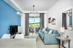 a living room with a blue couch and a tv at Agreste Luxury Apartments in Paliouri