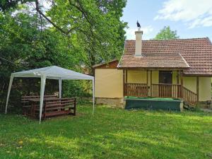 una casa con tenda e panchina nel cortile di Zuzka a Ižipovce