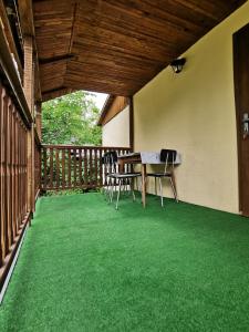 un tavolo e sedie su un portico con erba verde di Zuzka a Ižipovce