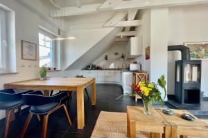 una cucina a pianta aperta e una sala da pranzo con tavolo e sedie in legno di Ferienwohnung4 im Haus Möwe a Thiessow