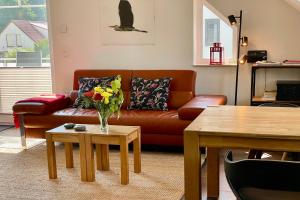 Ferienwohnung4 im Haus Möwe في ثيسو: غرفة معيشة مع أريكة و إناء من الزهور على طاولة
