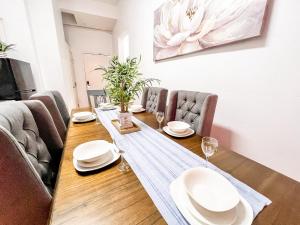 mesa de comedor con platos y sillas blancos en Gaslamp 2bdrm - W Parking & 5 Beds #403 en San Diego