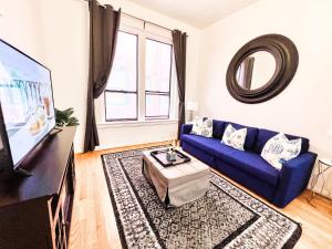 un salon avec un canapé bleu et une télévision dans l'établissement Gaslamp 2bdrm - W Parking & 5 Beds #403, à San Diego