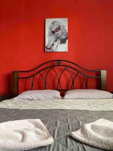 um quarto vermelho com uma cama com uma parede vermelha em Cleopatra's Cozy Cottage em Keramotí