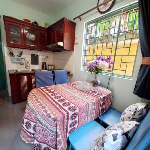 a kitchen with a table with a vase of flowers on it at Camelia Homestay in Hanoi