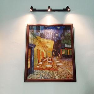 a painting of a restaurant hanging on a wall at Camelia Homestay in Hanoi