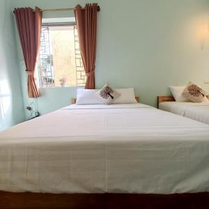 a bedroom with two beds and a window at Camelia Homestay in Hanoi