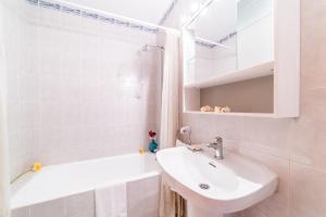 ein weißes Badezimmer mit einem Waschbecken und einer Badewanne in der Unterkunft Rosas 28 in Sa Coma