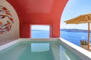 a swimming pool with a view of the ocean at Nano Oia Canaves in Oia