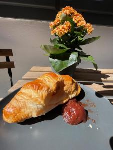 a plate with a croissant and a strawberry on a table at Ruttner Suite in Veszprém