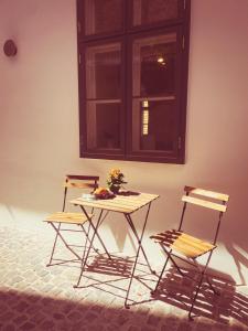 a table and two chairs in a room with a window at Ruttner Suite in Veszprém