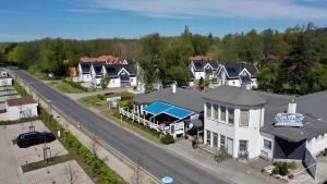 eine Luftansicht auf ein großes weißes Haus und eine Straße in der Unterkunft Hotel Windland in Breege