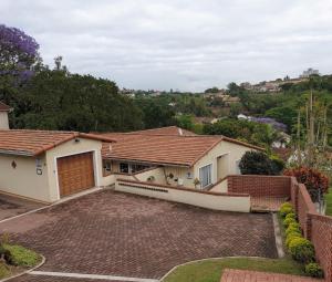 a house with a driveway and a garage at Lily's Cottage in Durban