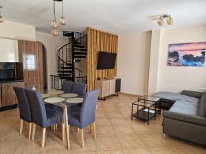 een woonkamer met een tafel en stoelen en een bank bij Casa Mia in Caleta De Fuste