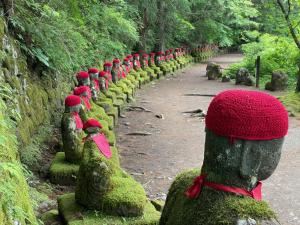a row of moss covered statues in a forest at 森のうた Morinouta Forest Stay in Nikko in Nikko