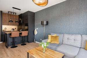 a living room with a couch and a table at Modern Apartment Górczyńska & Parking & Balcony by Renters Prestige in Poznań
