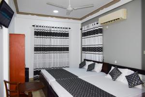 a bedroom with a bed and a tv in it at White Moon Beach Resort in Trincomalee