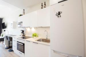 una cocina con armarios blancos y fregadero en Apartment Aurinkoranta D8 saunallinen yksiö Kalajoki, en Kalajoki