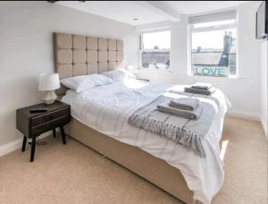 a bedroom with a large bed with a love sign on the wall at The loft at Mayfield, Harrogate in Harrogate