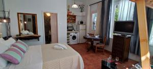 a bedroom with a bed and a television and a kitchen at Dream Catcher Studio in Skopelos Town
