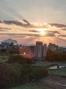 uitzicht op een stad met zonsondergang bij Haiyu Island Spring Apartment in Toucheng