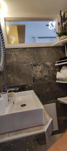 a bathroom with a white sink in a room at Dream Catcher Studio in Skopelos Town +12 photos