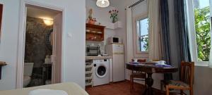 a small kitchen with a washing machine and a table at Dream Catcher Studio in Skopelos Town