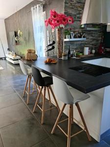 una cocina con encimera negra y sillas en Maison contemporaine aux portes des cevennes, en Alès