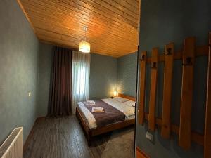 sypialnia z łóżkiem i drewnianym sufitem w obiekcie Hotel VIM in Sighnaghi w mieście Sighnaghi