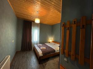 a bedroom with a bed with a wooden ceiling at Hotel VIM in Sighnaghi in Sighnaghi