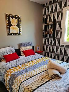 1 dormitorio con 2 camas y una foto de gato en la pared en Maison contemporaine aux portes des cevennes, en Alès